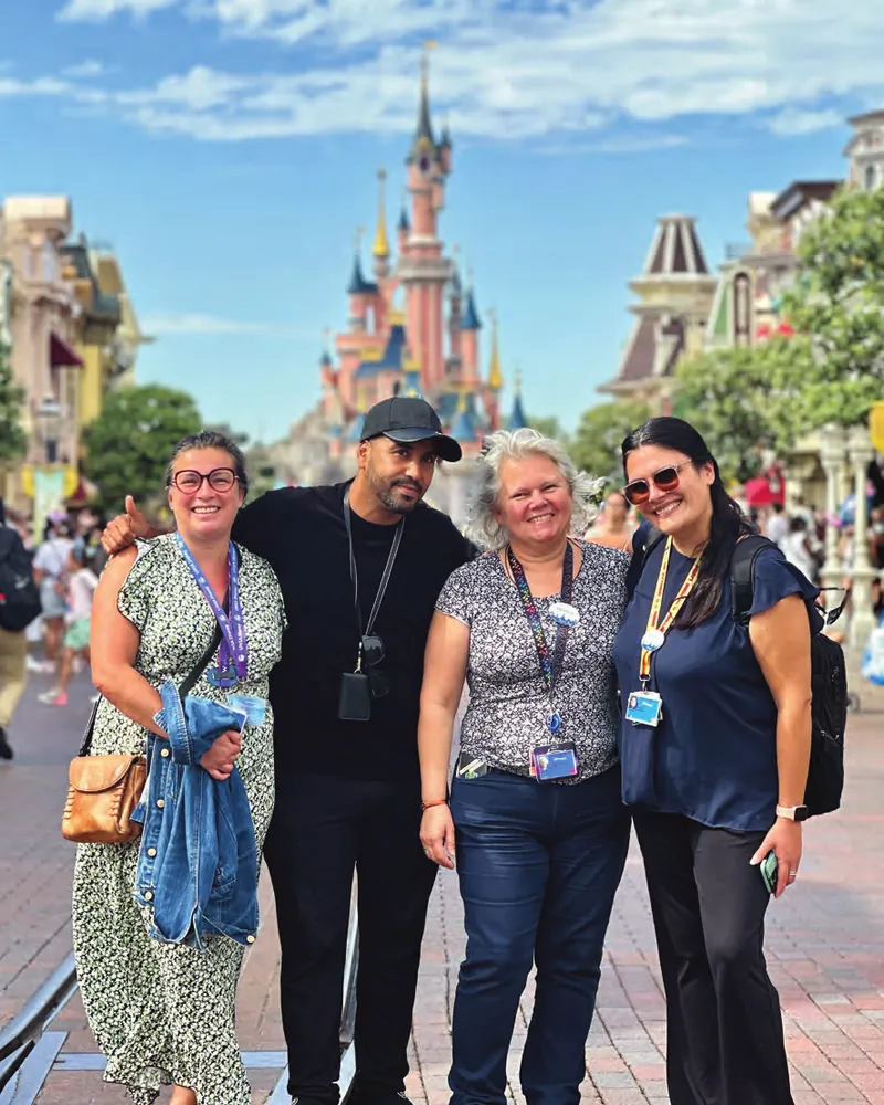 Quatre militantes et militants de l'UNSA Disneyland Paris devant le château de la Belle au bois dormant